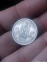 Close-up of the reverse side of the 1949 England one shilling coin showing crowned lion on crown and inscriptions