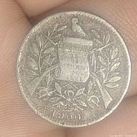 Obverse side of the 1900 Guatemala 1 Real silver coin showing the year 1900 with scroll and wreath design.