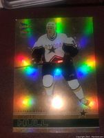 Gold holographic Bret Hull hockey card featuring Hull in Dallas Stars uniform with rainbow holo shine, close-up view.