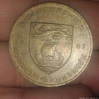 Front side of the token showing New Brunswick coat of arms, year 1967, and bilingual text.