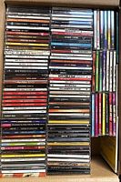 Full overview of over 125 CDs stacked in rows inside a box showing various artists and colorful spines.