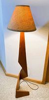 Front view of the teak floor lamp with woven fabric shade