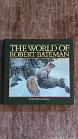 Front cover of 'The World of Robert Bateman' coffee table book showing a squirrel on a snow-covered tree branch, signed by Robert Bateman.
