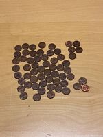 Overview of 59 Lincoln Wheat pennies laid out on table, mostly 1955 Philadelphia mint coins