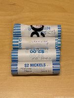 Four paper-wrapped rolls of Jefferson nickels labeled with type and date, stacked horizontally.