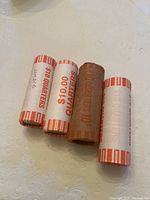 Four rolls of wrapped Duke Ellington DC State Quarters, showing face of rolls and markings