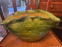 Clamshell shaped Vietnamese earthenware vase with green mottled glaze side view