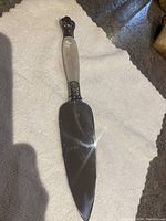 Full view of the Birks cake server showing mother of pearl handle, ornate silver plate ferrule, and stainless steel blade.