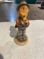 Front view of Hummel figurine showing boy playing horn with detailed hand-painted colors.
