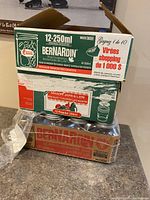 Stacked boxes of Bernardin mason jars in various sizes including 12-250ml decorative jars and jam-sized jars.