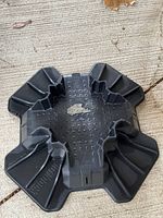 Top view of a single black plastic Tuff Block building block with ribs and grooves for structure.