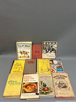 Photo showing the full collection of 11 vintage cookbooks from various publishers and themes.