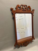Front perspective view of the Georgian style carved wall mirror showing decorative wooden frame and clear mirror glass.