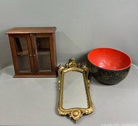 Photo showing lacquered bowl, tabletop curio cabinet, and ornate mirror together