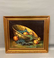 Front view of the framed still life oil painting showing fruit in gold bowl with grapes and peaches.