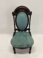 Front view of Victorian lady's side chair showing oval backrest and upholstered seat in blue velvet, wooden carved frame with turned legs and decorative crest.