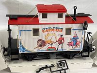 Front and side view of the LGB Circus train car showing detailed circus-themed artwork and red roof.