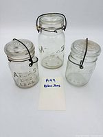 Front view of three Atlas E-Z Seal jars, showing embossed logos and closures