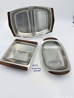 All three stainless steel serving dishes with wood handles displayed