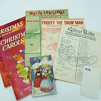 Front covers of five Christmas carol songbooks and sheet music