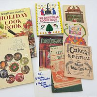 Group shot of all eight holiday cookbooks and booklets laid out