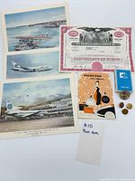 Overall view showing postcards, stock certificate, brochure, playing cards, hat badge, buttons