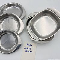 Set of seven stainless steel dishes showing both shapes