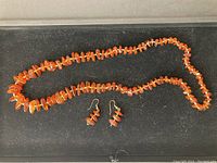 Full view of amber bead necklace laid out with matching amber bead earrings, showing size and style of set.