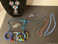 Full view of all bead work costume jewelry items including necklaces and bracelets on flat surface.