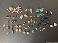 One photo showing a collection of assorted clip-on earrings arranged on a dark surface including floral designs, colored stones, faux pearls, and geometric shapes.