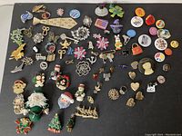 Full spread of approximately 54 mixed vintage brooches varying sizes and themes including Christmas, floral, animals, and novelty pins.
