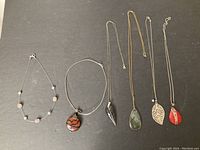 Overview of all six necklaces laid out to display their design variety and pendants.