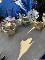 Lot of 4 white ceramic hanging planters with ropes and 2 bird-shaped ceramic planters on a table