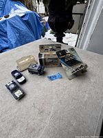 Five vintage die cast Toronto Maple Leaf toy cars and ice resurfacer displayed on a table outdoors