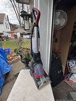 Full side view of the Hoover carpet cleaner with visible handle, tank, and nozzle.