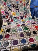 Full display of the large granny square blanket, showing overall pattern and colors.