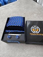 Photo of the new in box men's tie gift set from Tieworld.org showing tie, cufflinks, tie clip, and hanky with blue geometric pattern.
