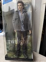 Front view of the vintage Twilight Edward Barbie doll in original packaging, showing the doll wearing a gray coat, blue shirt, black pants, and black shoes, with Twilight branding visible.