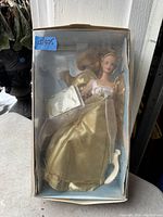 Vintage Barbie doll in gold angelic dress inside original box with protective plastic. Box shows some wear but intact.