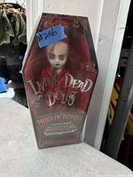 Photo of vintage Living Dead Dolls Carotte Morts doll in original coffin-shaped box, showing doll with pale face and makeup, unopened.