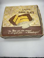 Original decorated box for vintage Tonee White cake stand, featuring cake slice graphics and branding.