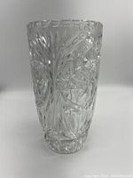 Side view of an 8 inch tall cut crystal vase showing detailed geometric and floral patterns.