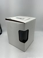 Closed white box with cutout showing one glass inside.