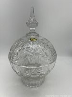 Front view of the lidded crystal dish showing its detailed cut pattern and finial top.