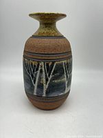 Front view of pottery vase showing tree design and flared top.