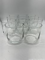 Front view of 11 vintage Libbey swirl glasses showing clear glass with swirled textured design.