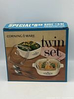 Photo of Corning Ware Twin Set box showing 2 dishes with lids and spoons on the package front.