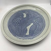 Top view of the 15-inch oval ceramic platter showing embossed blue-gray design of horse and rider.