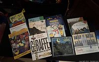 Photo of 12 children's books spread out showing colorful illustrated covers including titles such as Giraffe Problems and Minions Snow Day.