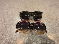 Photo showing two pairs of sunglasses, one round with gradient brown lenses, one square with black beaded frame.
